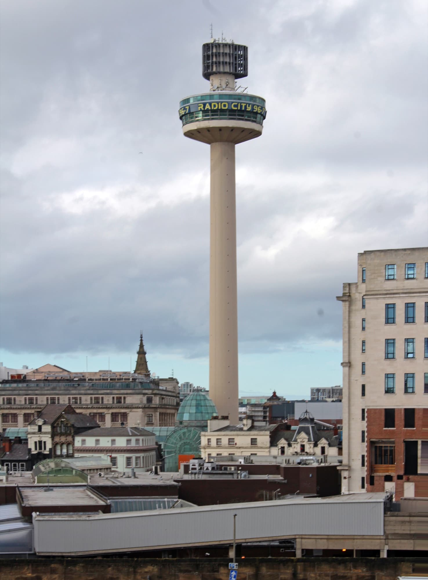 St John's Beacon (Radio City Tower) rising above Liverpool city centre rooftops, seen from a car park on Heathfield Street, near St Johns Shopping Centre.