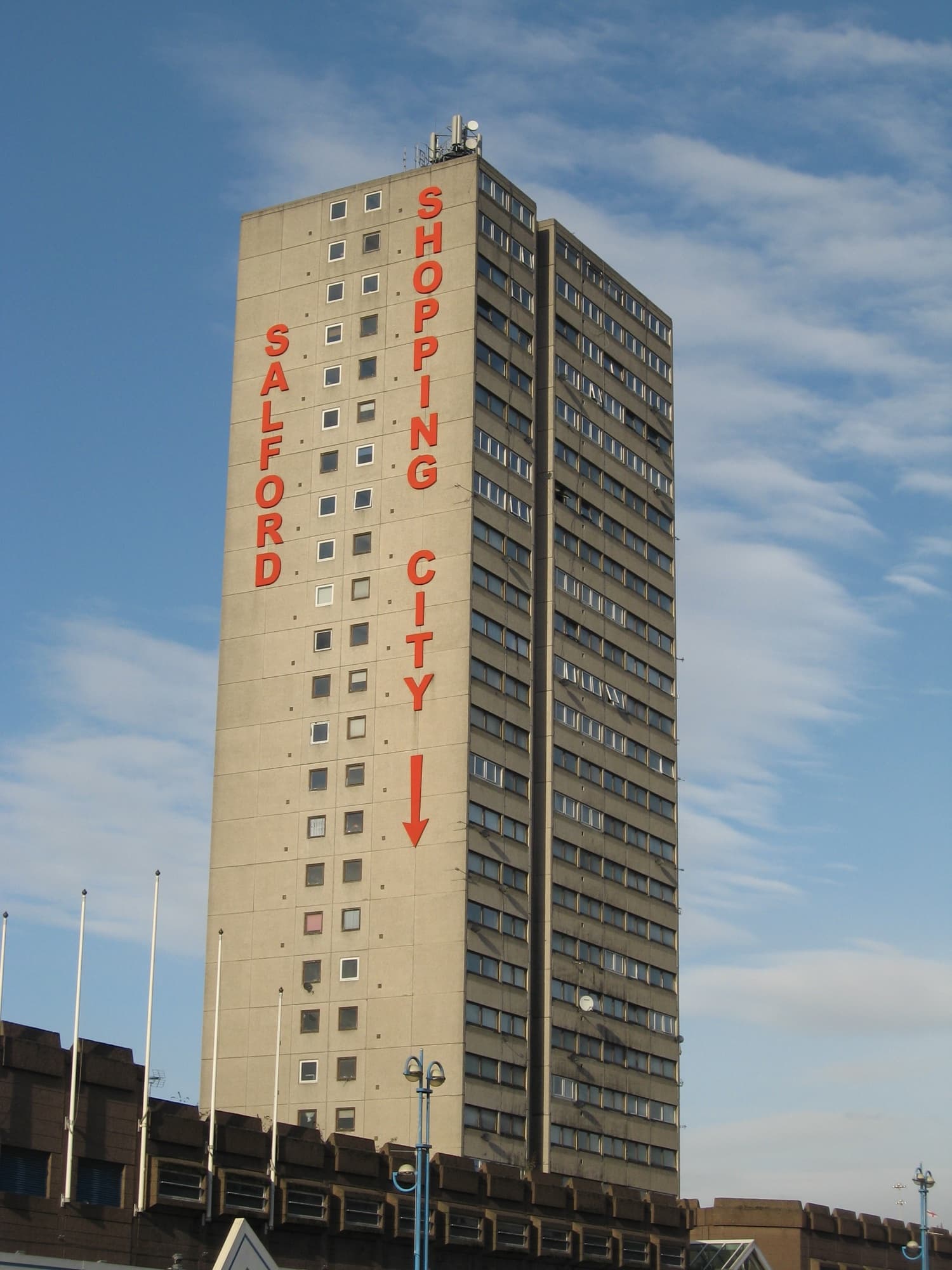 The landmark tower block of Salford Shopping City (the renamed, redeveloped Salford Precinct), Salford, against a clear blue sky.