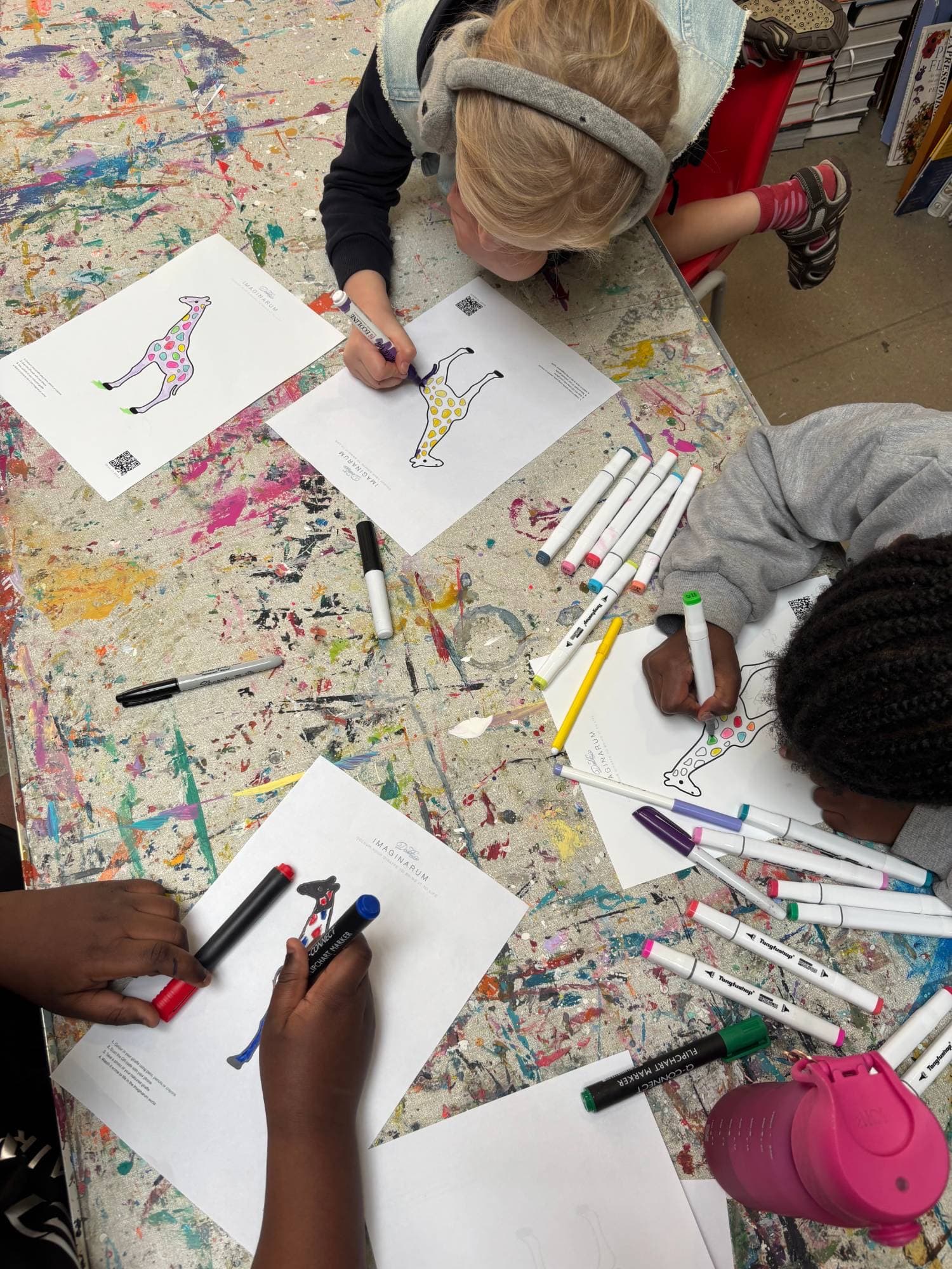 Children colouring giraffes at a Doddz workshop