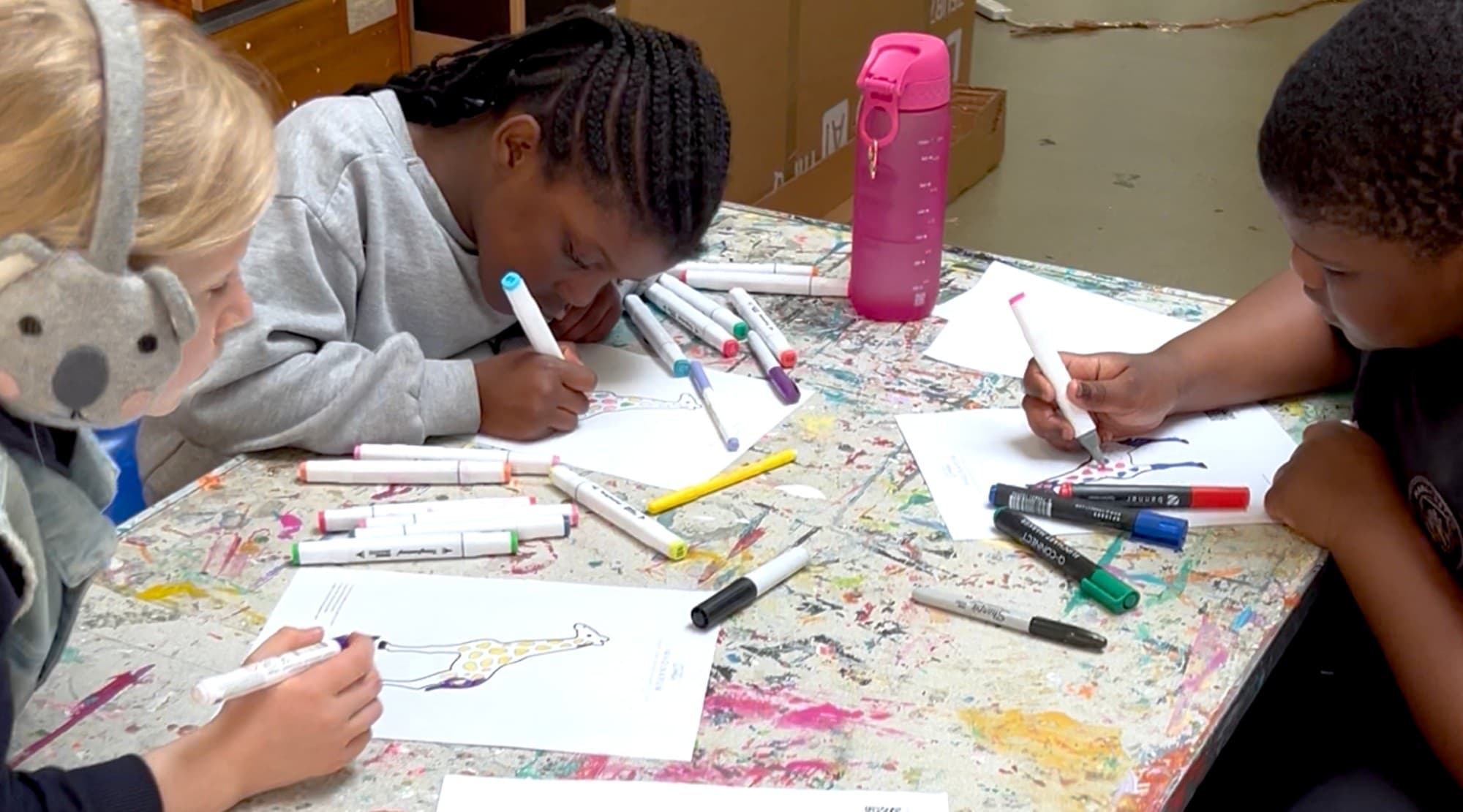 Three children colouring at the table
